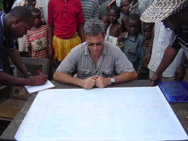 Michael Brown reviewing documents with colleagues in the field